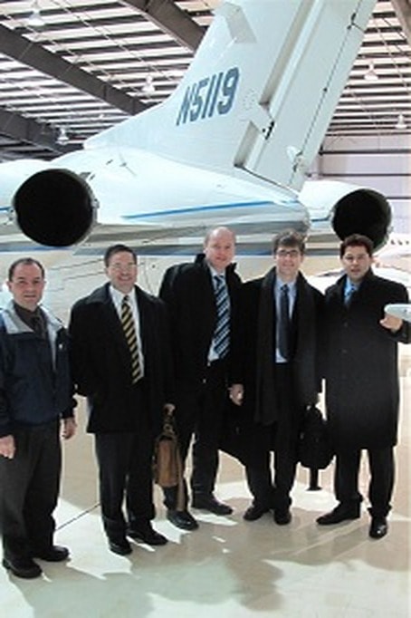 Delegation in front of a business jet in a hangar